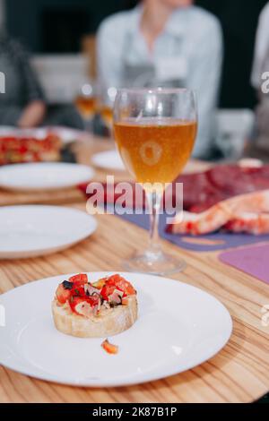 Bruschetta mit Fisch und Tomaten auf schwarzem Teller. Italienische Bruschetta in einem Kochkurs. Hausgemachtes Essen, Kochen zu Hause. Stockfoto