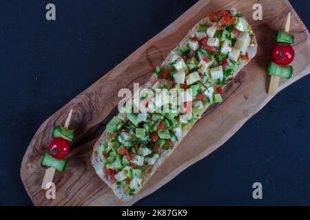 Bruschetta mit Tomaten, Mozzarella und Basilikum auf einem alten rustikalen Tisch. Traditionelle italienische Vorspeise oder Snack, Vorspeise Stockfoto