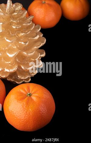 Eine Kerze mit Mandarinen auf schwarzem Hintergrund Stockfoto