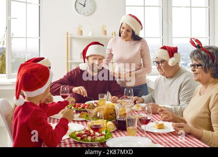 Die junge Frau kümmert sich zu Hause während der traditionellen Weihnachtsfeiertage um ihre Familie. Stockfoto