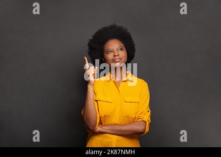 Smart erfolgreiche selbstbewusste Frau Poiting up auf schwarzen Studio Wand Banner Hintergrund Stockfoto