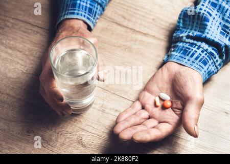 Viele bunte Pillen in den Händen eines Senior Stockfoto