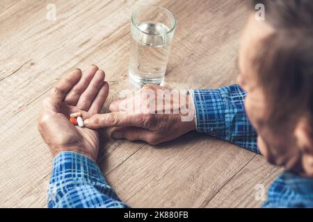 Viele bunte Pillen in den Händen eines Senior Stockfoto