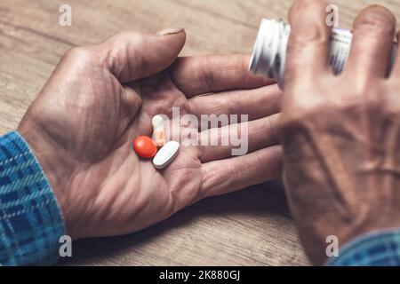 Viele bunte Pillen in den Händen eines Senior Stockfoto