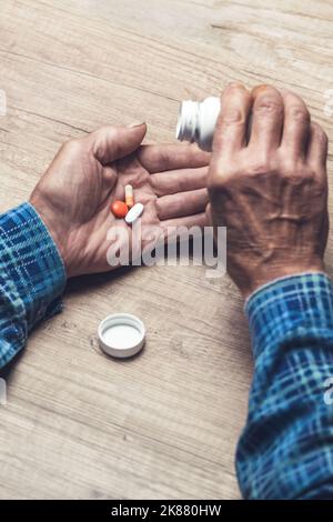 Viele bunte Pillen in den Händen eines Senior Stockfoto