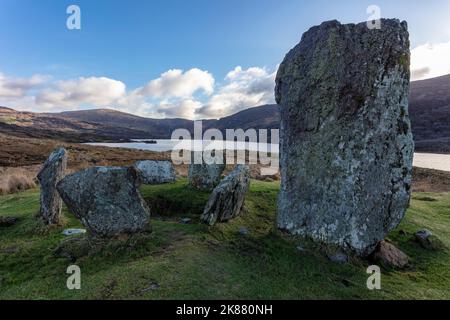 Eine malerische Aussicht auf den Uragh Stone Circle gegen einen See und Berge im Gleninchaquin Park, County Kerry, Irland Stockfoto