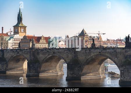 Teil der Karlsbrücke in Prag, gesehen vom linken Ufer der Moldau, an einem klaren Herbsttag. Touristen und Altstadt Skyline sind sichtbar. Stockfoto