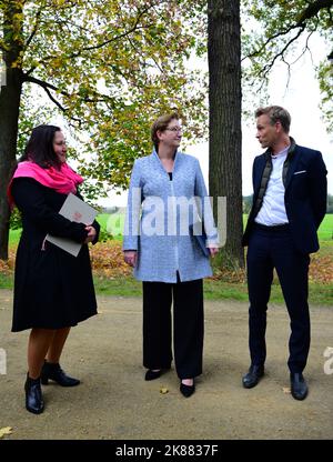 21. Oktober 2022, Brandenburg, Cottbus/OT Branitz: Stefan Körner (r), Direktor der Prinz-Pückler-Park- und Schloss-Branitz-Stiftung (SFPM), Klara Geywitz (M, SPD), Bundesministerin für Bau und Wohnen, und Manja Schüle (l, beide SPD), Brandenburgische Ministerin für Wissenschaft, Forschung und Kultur, sprechen im Branitz-Park. Vorgestellt wurde das Modellprojekt der Bundesregierung "New Tree University Branitz" zur Erhaltung historischer Gärten im Klimawandel. Auf dem Gelände eines ehemaligen Marktgartens soll eine neue Ära der 176-jährigen Branitz-Baumuniversität entstehen. Das Außenpar Stockfoto