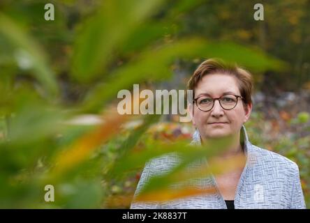 21. Oktober 2022, Brandenburg, Cottbus/OT Branitz: Klara Geywitz (SPD), Bundesministerin für Bau und Wohnen, steht hinter einem jungen Edelkastanienbaum in der Altbauuniversität des historischen Schlossgartens der Stiftung Fürst-Pückler-Museum Park und Schloss Branitz. Vorgestellt wurde das Modellprojekt 'New Tree University Branitz' der Bundesregierung zur Erhaltung historischer Gärten im Klimawandel. Auf dem Gelände eines ehemaligen Marktgartens soll eine neue Ära der 176 Jahre alten Branitz Tree University entstehen. Der Outdoor-Park wird große Anbauflächen für bieten Stockfoto