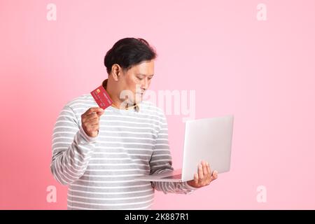 Der 40s Erwachsene übergewichtige asiatische Mann, der auf dem rosa Hintergrund steht. Stockfoto