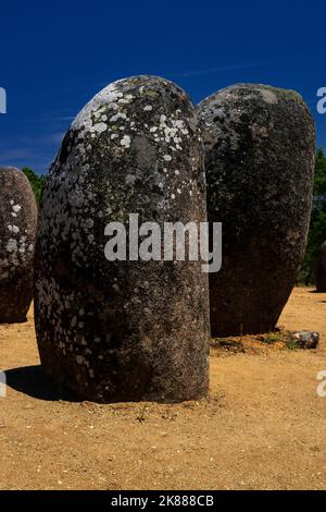 Zerkratzte Linien und geschwungene prähistorische Symbole sind noch immer nur auf der Flechten-bedeckten Oberfläche einiger der abgerundeten Granitfelsen zu sehen, die in Kreisen zu dem 7.000 Jahre alten Almendres Cromlech bei Évora in Alentejo, Portugal, gruppiert sind. Der Megalithkomplex, bekannt als portugiesischer Stonehenge, ist mindestens 2.000 Jahre älter als das weltberühmte Denkmal in Wiltshire, England. Stockfoto