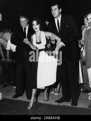 George Stevens, Elizabeth Taylor & Rock Hudson Regisseur, Schauspielerin und Schauspieler (USA 1956) / Bei der Premiere von 'Giganten' 10 October 1956 **WARNUNG** Dieses Foto ist nur für redaktionelle Verwendung bestimmt und unterliegt dem Copyright der Filmgesellschaft und/oder des Fotografen, der von der Film- oder Produktionsgesellschaft beauftragt wurde, und kann nur durch Publikationen im Zusammenhang mit der oben genannten Promotion reproduziert werden Film. Eine obligatorische Gutschrift an die Filmgesellschaft ist erforderlich. Der Fotograf sollte auch bei Bekanntwerden des Fotos gutgeschrieben werden. Ohne schriftliche Genehmigung der Film Company kann keine kommerzielle Nutzung gewährt werden. Stockfoto