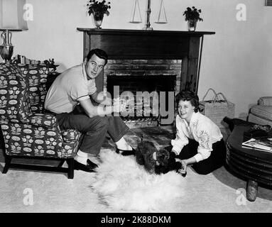 Rock Hudson & Phyllis Gates Actor at Home with Wife and Dog 01 May 1957 **WARNUNG** Dieses Foto ist nur für den redaktionellen Gebrauch bestimmt und unterliegt dem Copyright der Film Company und/oder des Fotografen, der von der Film- oder Produktionsfirma beauftragt wurde und kann nur durch Publikationen in Verbindung reproduziert werden Mit der Förderung des oben genannten Films. Eine obligatorische Gutschrift an die Filmgesellschaft ist erforderlich. Der Fotograf sollte auch bei Bekanntwerden des Fotos gutgeschrieben werden. Ohne schriftliche Genehmigung der Film Company kann keine kommerzielle Nutzung gewährt werden. Stockfoto