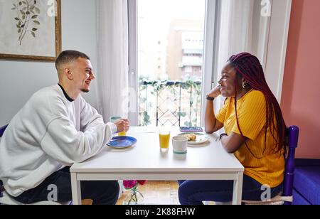 Multirassisches Paar beim Frühstück zu Hause Stockfoto