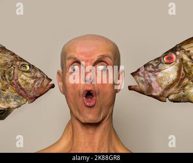 Fish Face, ein freakisches Porträt eines Mannes und eines Fisches Stockfoto