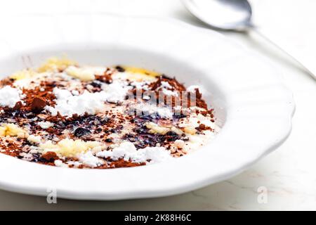 Grießbrei mit Kakao, Zucker und geschmolzener Butter Stockfoto