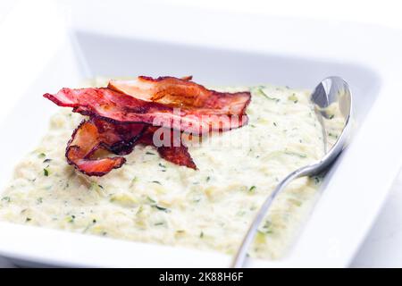 Zucchini-Suppe mit Speckstreifen Stockfoto