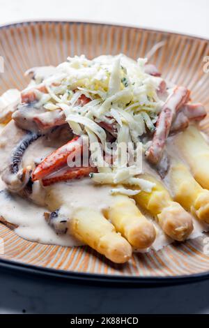 Weißer Aparagus mit Pilzsauce und Schinken, serviert mit Blauschimmelkäse Stockfoto