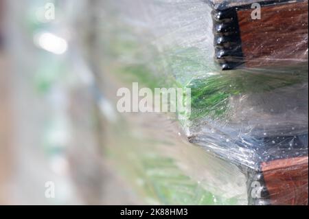 Selektiver Fokus auf Zellophan-Schrumpffolie auf Paletten von Waren für den Transport. Stockfoto