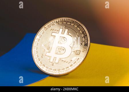 Bitcoin und Flagge der Ukraine. Kryptowährung in der Ukraine. Bezahlung von Waren. Ländermünze. Internetwährung im Land. Stockfoto