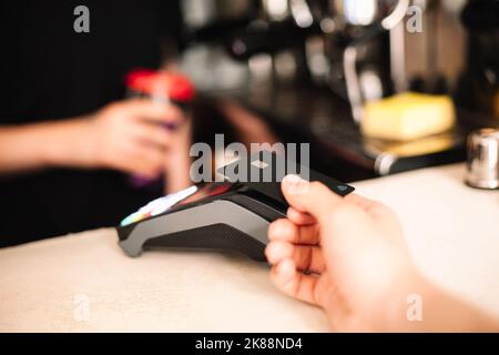 Kunde, der kontaktlose Zahlung per Kreditkarte abgibt Stockfoto