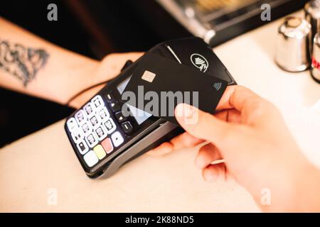Kunde, der kontaktlose Zahlung per Kreditkarte abgibt Stockfoto