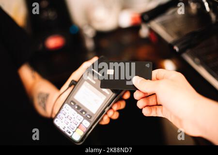 Kunde, der kontaktlose Zahlung per Kreditkarte abgibt Stockfoto
