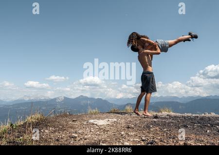 Ein junges Paar, das Spaß auf dem Hügel hat Stockfoto