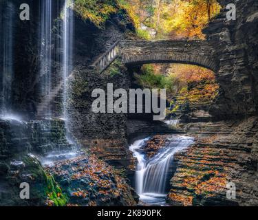 Watkins Glen Rainbow Falls New York - Herbstbäume und Herbstlaub in felsigen Schluchtenfarben in Finger Lakes - Wasserfall Bridge Wasserfälle im US State Park Stockfoto