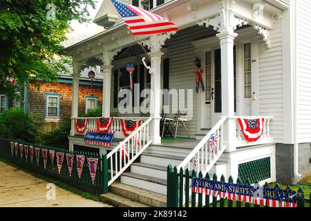 Am 4. Juli fliegt eine amerikanische Flagge von der Veranda eines historischen Hauses in Bristol, Rhode Island Stockfoto