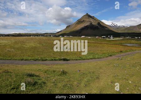 Über dem Dorf Arnarstapi auf der Halbinsel Snæfellsnes ragt der Berg Stapafell, der im Westen Islands aufgenommen wurde. Stockfoto