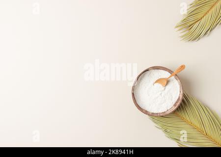 Kollagenpulver mit Messlöffel mit Palmblättern auf pastellbeigem Hintergrund. Flach liegend, Kopierplatz Stockfoto