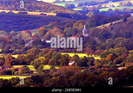 Die Farben des Herbstes umhüllen das Dorf East Meon in der Nähe von Petersfield, Hampshire, in der Morgensonne. Die Allerheiligen-Kirche aus dem 12.. Jahrhundert ist von Bäumen aller Schattierungen umgeben, bevor sie im Herbst ihre Blätter verlieren. Pic Mike Walker, Mike Walker Pictures Stockfoto