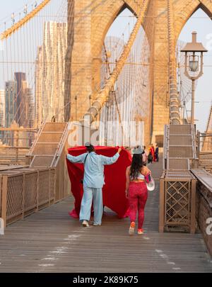 New York City, Vereinigte Staaten - 18. September 2022 Zufällige Fotosession auf der Brooklyn Bridge und ein Mädchen in Leggings, das vorbei geht Stockfoto