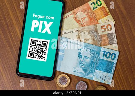 Pix auf dem Smartphone-Bildschirm mit mehreren Münzen um. Pix ist das neue Zahlungs- und Transfersystem der brasilianischen und brasilianischen Regierung Stockfoto
