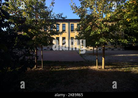 Garten einer Schule mit Basketballplatz bei Sonnenuntergang Stockfoto