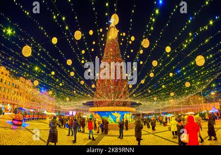 KIEW, UKRAINE - 28. DEZEMBER 2021: Der Weihnachtsbaum der Hauptstadt in hellen Lichtern und farbigen Girlanden gegen den dunklen Winterhimmel, am 28. Dezember in K Stockfoto