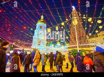 KIEW, UKRAINE - 28. DEZEMBER 2021: Abend Sophia-Platz mit herrlichem Weihnachtsbaum und dem Glockenturm der Sophia-Kathedrale in der hellen Stadt li Stockfoto