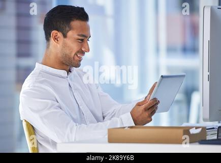 Erfolg im Leben ist, was Sie definieren, es zu sein. Ein Geschäftsmann mit einem digitalen Tablet, während er an seinem Schreibtisch sitzt. Stockfoto