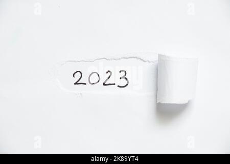 2023 geschrieben auf weißem zerrissenem Papier, glückliches neues Jahr 2023 Stockfoto