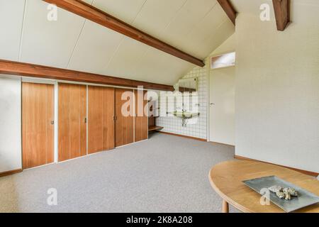 Holzschrank mit befindet sich in der Nähe Fenster und Schrank zum Lesen in hellen Raum zu Hause Stockfoto