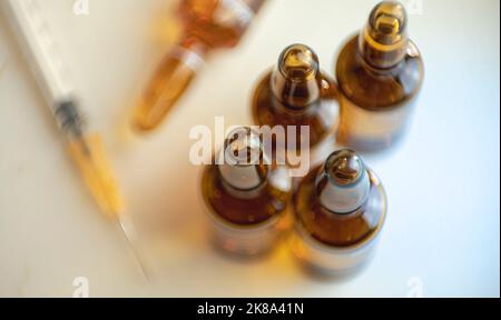 Zusammensetzung der Medizin aus fünf Injektionsfläschchen und Spritze auf weißem Tisch Stockfoto