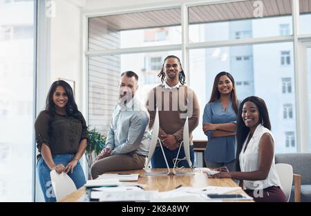 Nichts kann uns davon abhalten, Ziele zu erreichen. Ein Porträt einer Gruppe von Geschäftsleuten, die während einer Tagung im den Sitzungssaal umzinsen Stockfoto