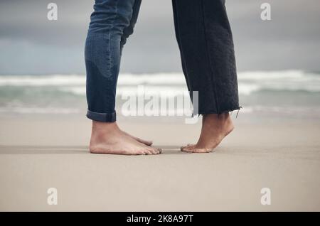 Der schönste Ort ist, wo immer ich bei dir bin. Ein unverkennbares Paar, das barfuß am Strand steht. Stockfoto