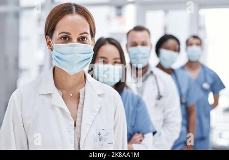 Seine riskante Arbeit, aber wir müssen es tun. Porträt einer Gruppe von Ärzten, die Gesichtsmasken in einem Krankenhaus tragen. Stockfoto