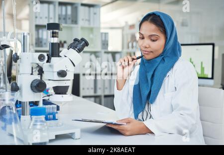 Wo die Wissenschaft hingeht, fließen Antworten. Ein junger Wissenschaftler, der in einem Labor forscht. Stockfoto