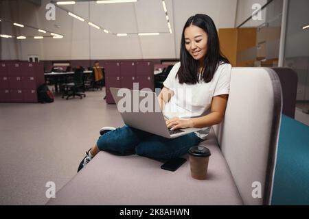 Die elegante asiatische Managerin reagiert im Workspace auf die E-Mails Stockfoto