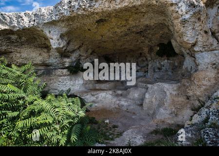 Blick auf den Eingang einer Höhle in der Schlucht zwischen der Stadt Miera und dem Naturpark Murgia Timone Stockfoto