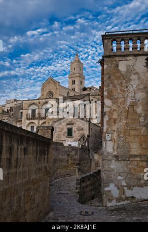 Stadtbild von Matera mit einer Gasse im Schatten und der Kathedralenfassade am Ende Stockfoto