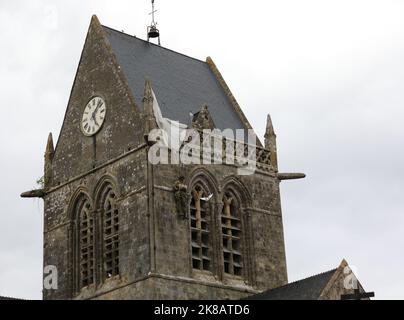 Sainte-Mere-Eglise, FRA, Frankreich - 21. August 2022: Kirche mit Fallschirmjäger auf dem Glockenturm Stockfoto